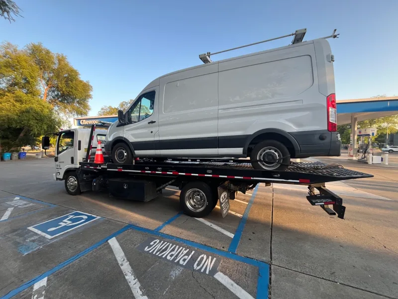 Mena's Towing flatbed transporting a commercial van